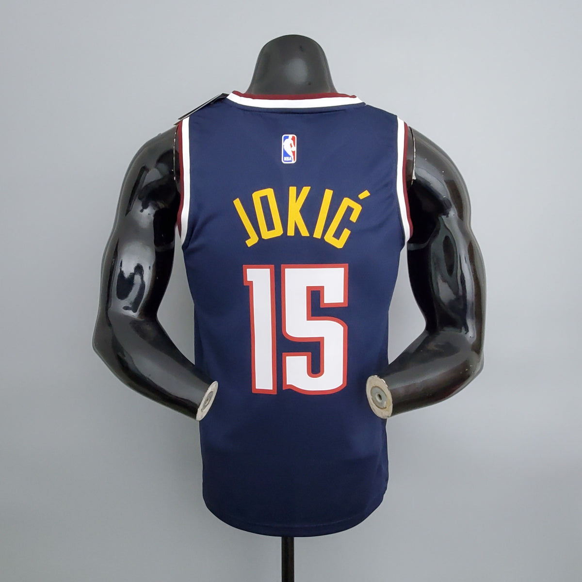 Gold Jokić name and white number 15 with red outline on jersey back