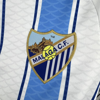 Close-up of the light blue stripe and fabric detail on the Málaga 2026/27 home jersey