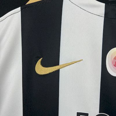 Angers Home Jersey 2025/26 close-up of gold-coloured chest logo and striped fabric