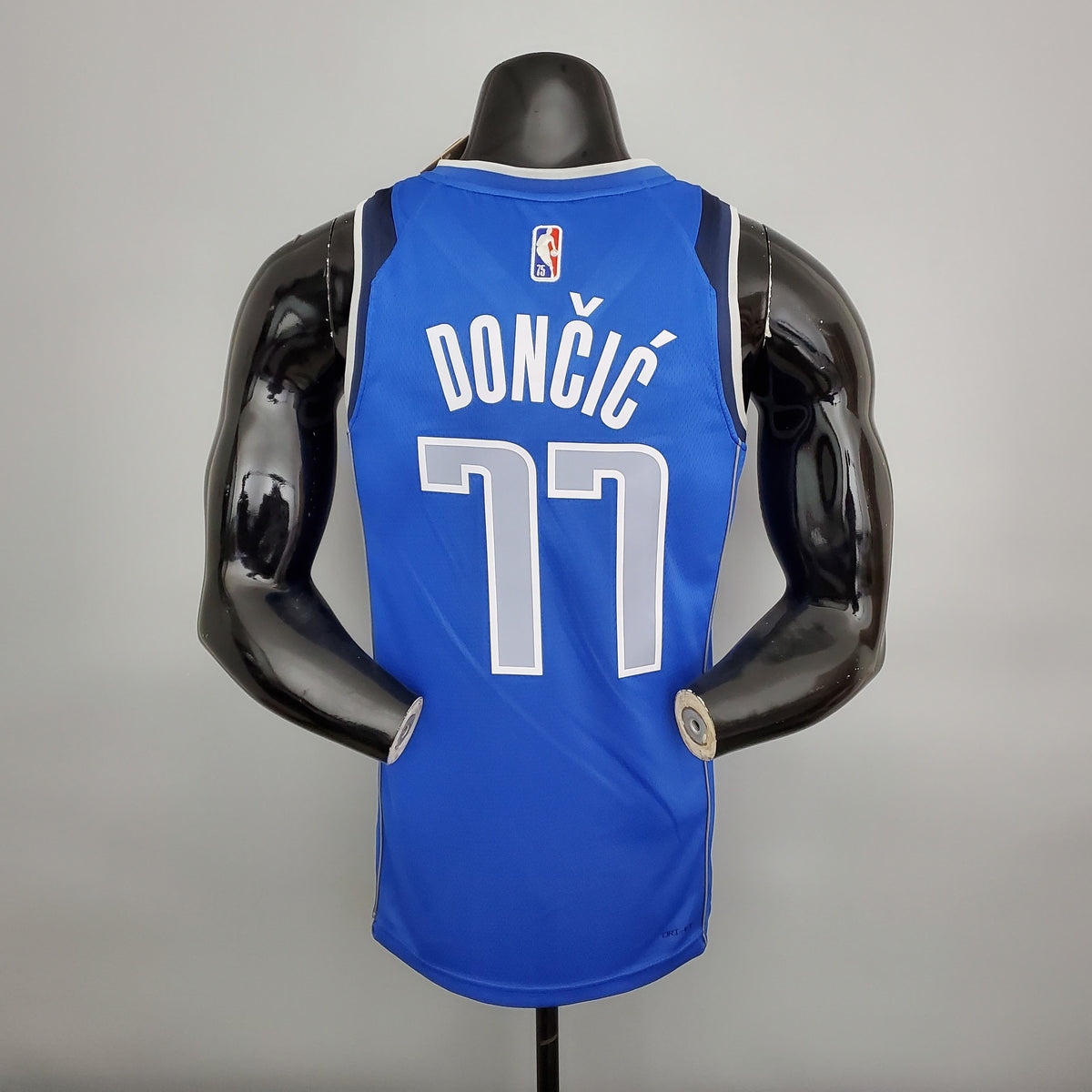 Dončić name and number 77 on the back of blue Mavericks jersey